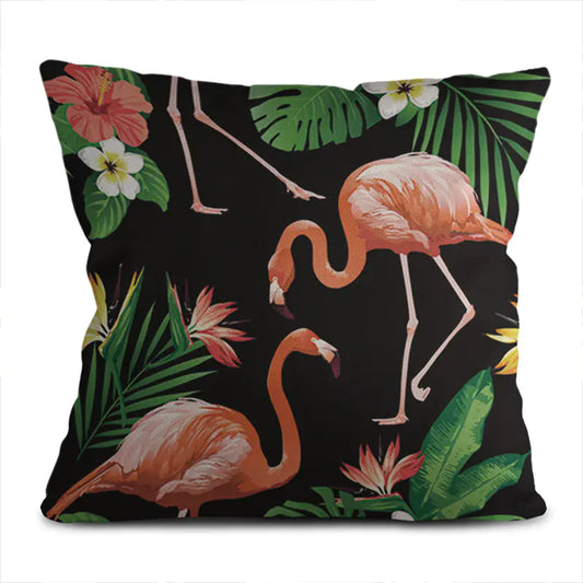 Decorative pillow with flamingo and tropical leaf design on a black background