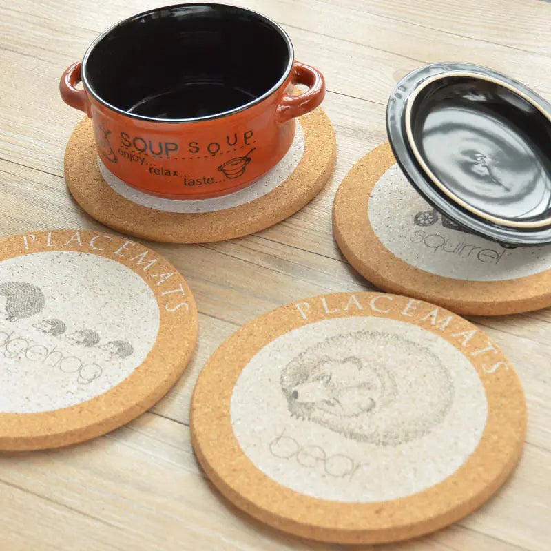 Set of cork coasters with printed designs on a wooden surface
