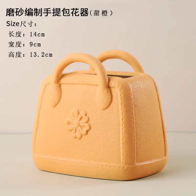 Yellow handbag-shaped flower pot with a flower design on a beige background