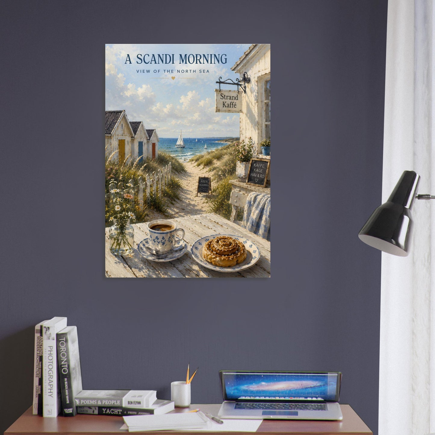 Nordic wall art displayed on a dark blue wall in a home office featuring a coastal café, coffee and cinnamon bun
