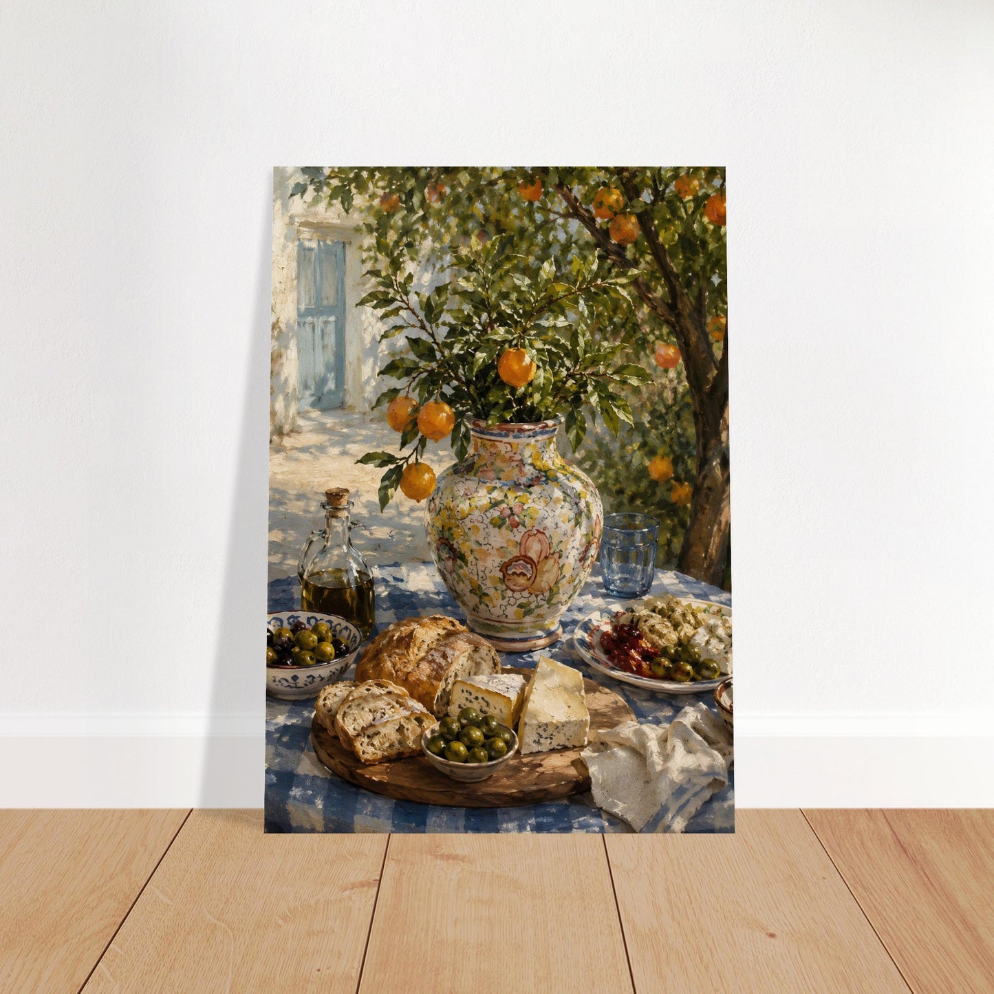 Mediterranean still life art print displayed on a wooden floor, leaning against a plain wall