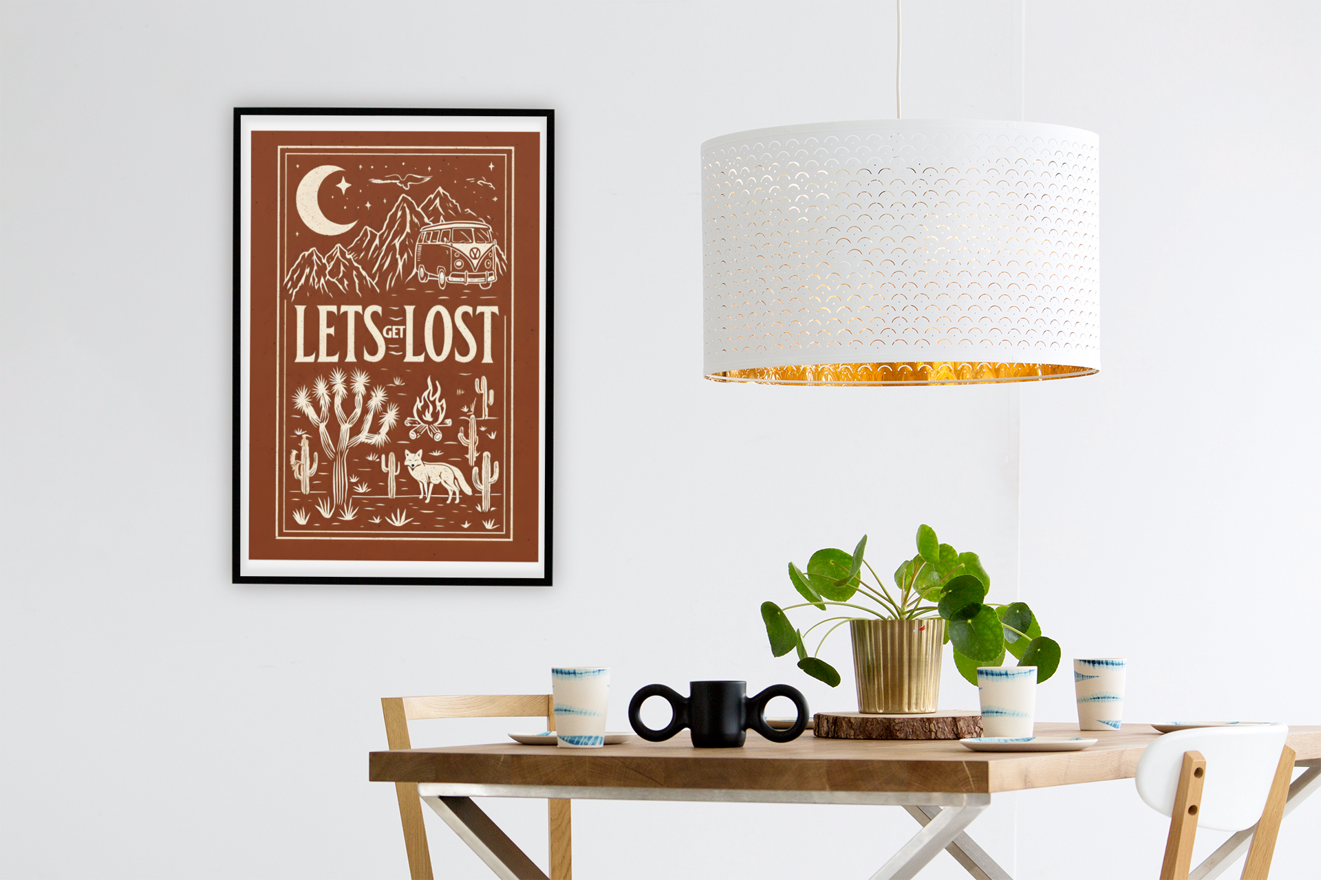 Let’s Get Lost poster – retro camper van and desert wall art, displayed in a modern dining room with wooden table, lamp, and plants