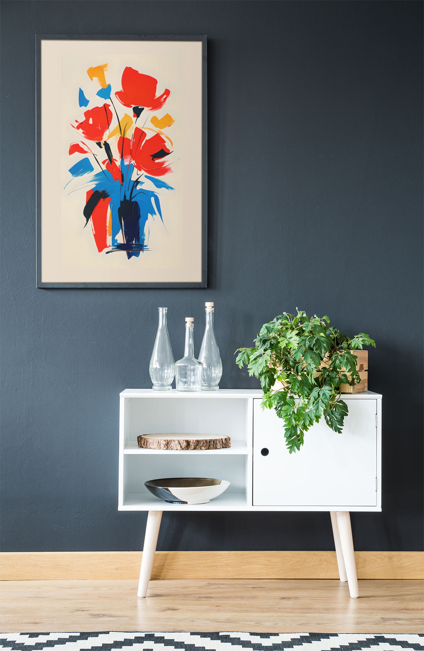 Abstract floral poster with bold red, yellow, and blue bouquet – modern colorful wall art framed on dark navy wall above white console with plant.