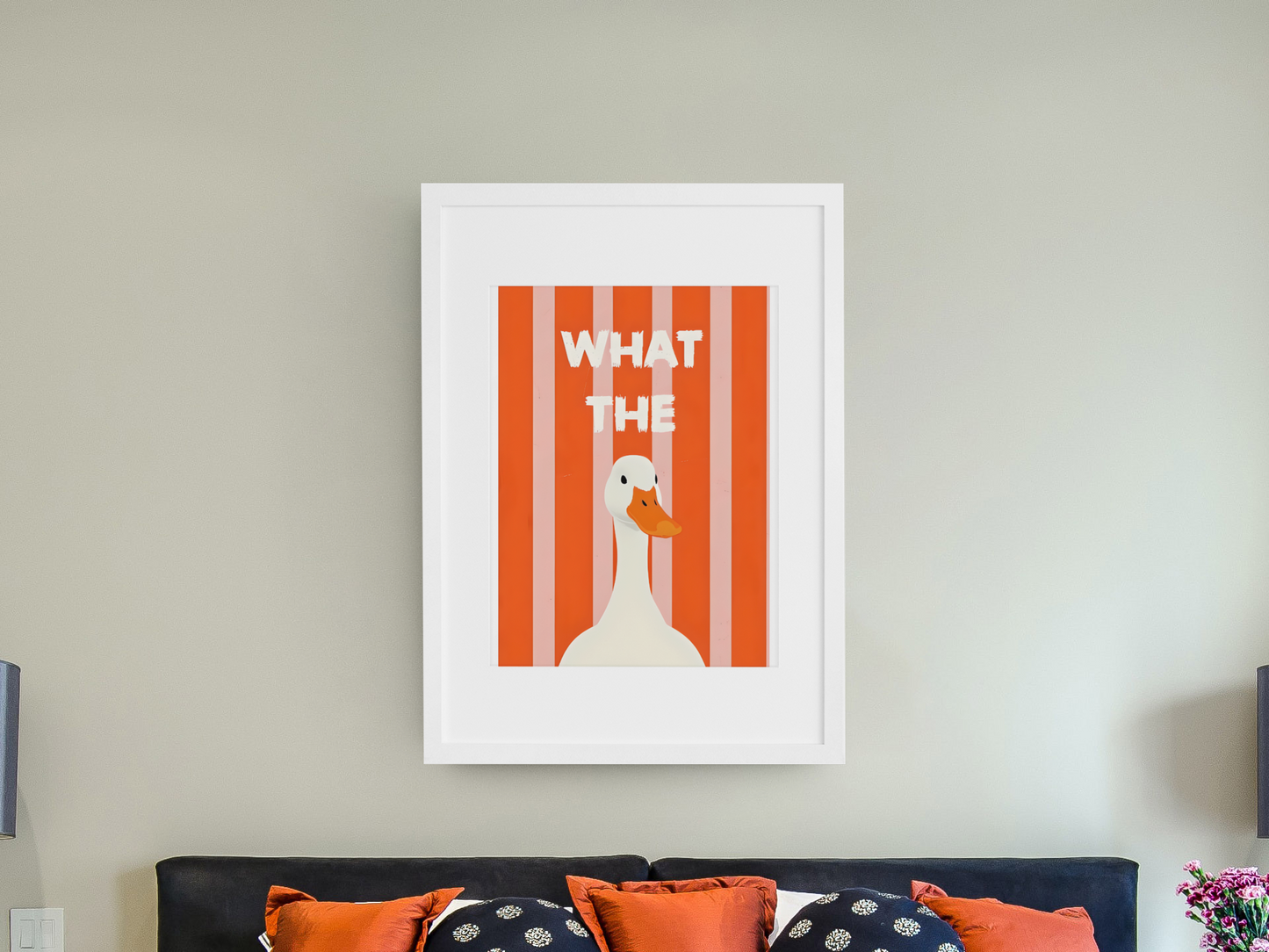 Framed artwork with a duck illustration and text on a wall above a bed.