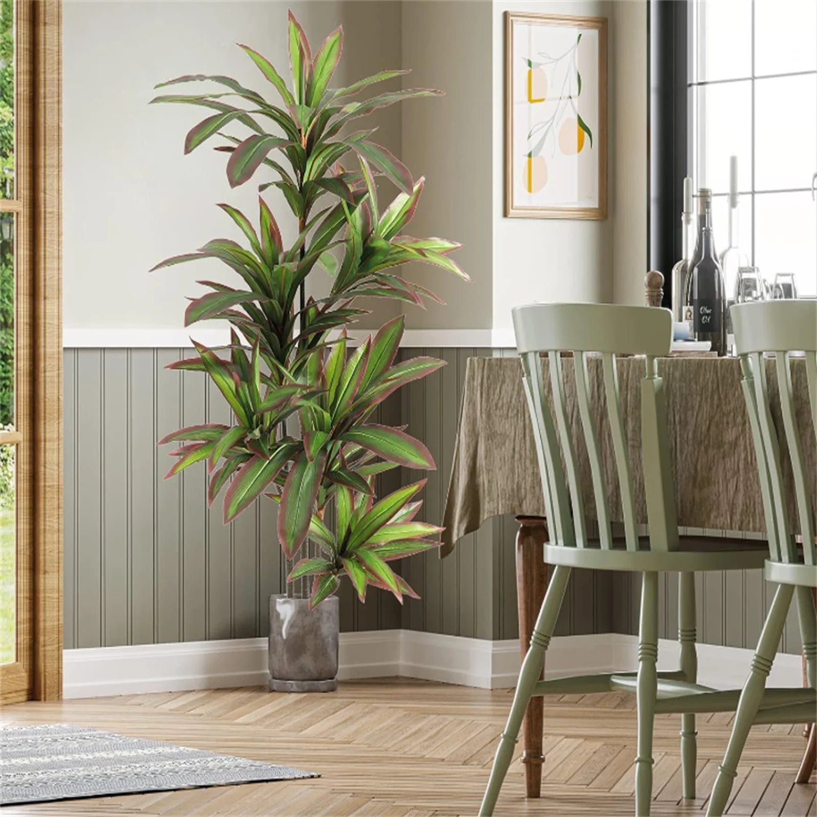 Tall Artificial green plant in a pot next to a dining table with chairs in a well-lit room.