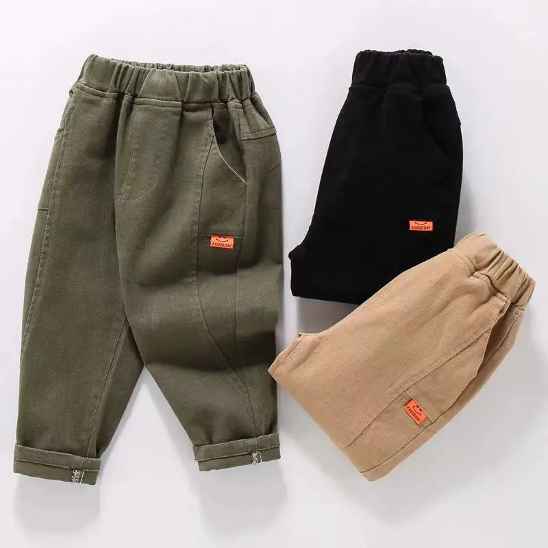 Three pairs of pants in green, black, and beige on a white background