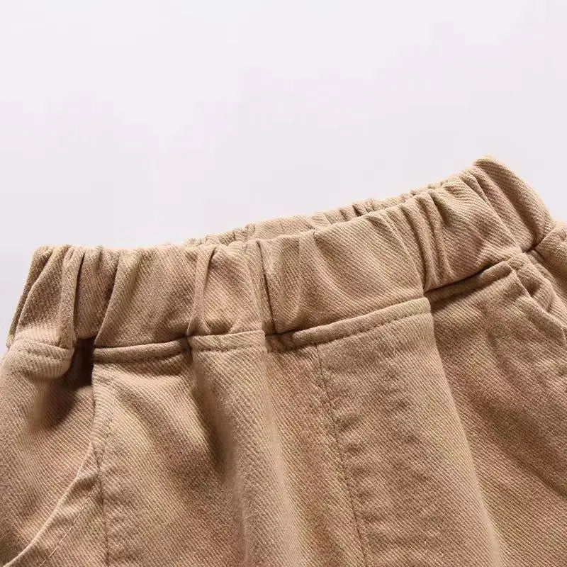 Close-up of beige pants with an elastic waistband on a light gray background