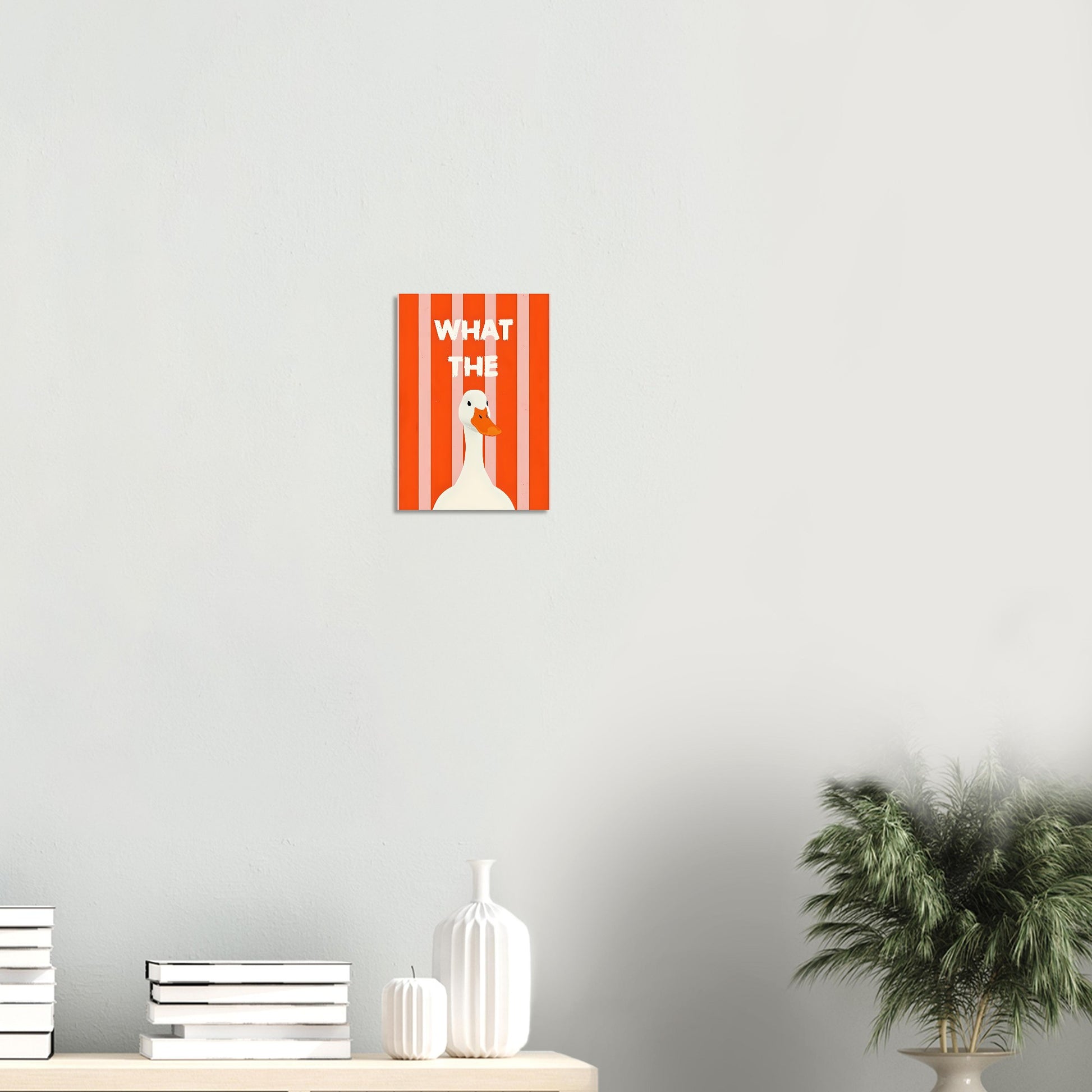 Poster with a duck illustration and text on a white wall with decor items below.