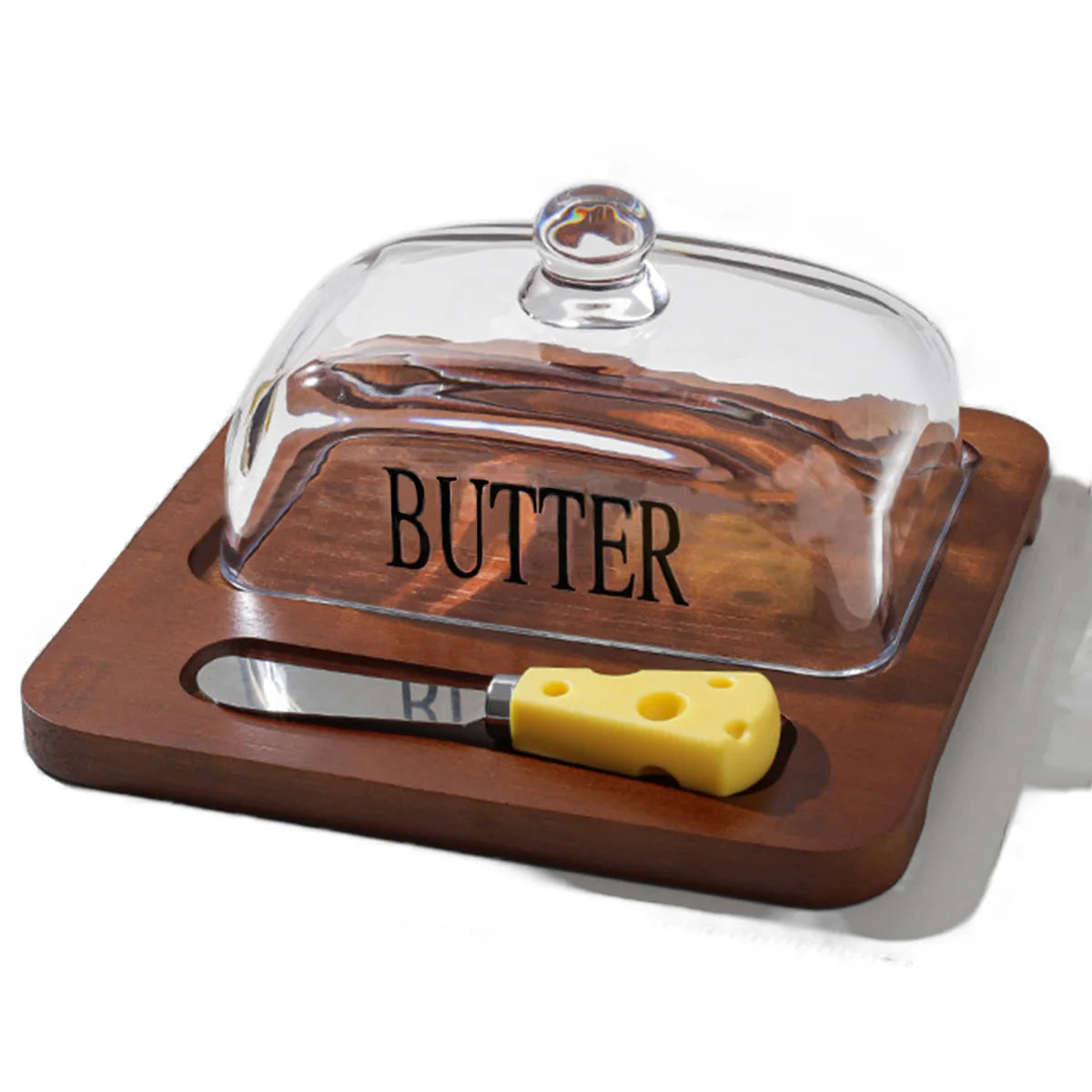 Wooden butter dish with glass cover and yellow knife on a white background