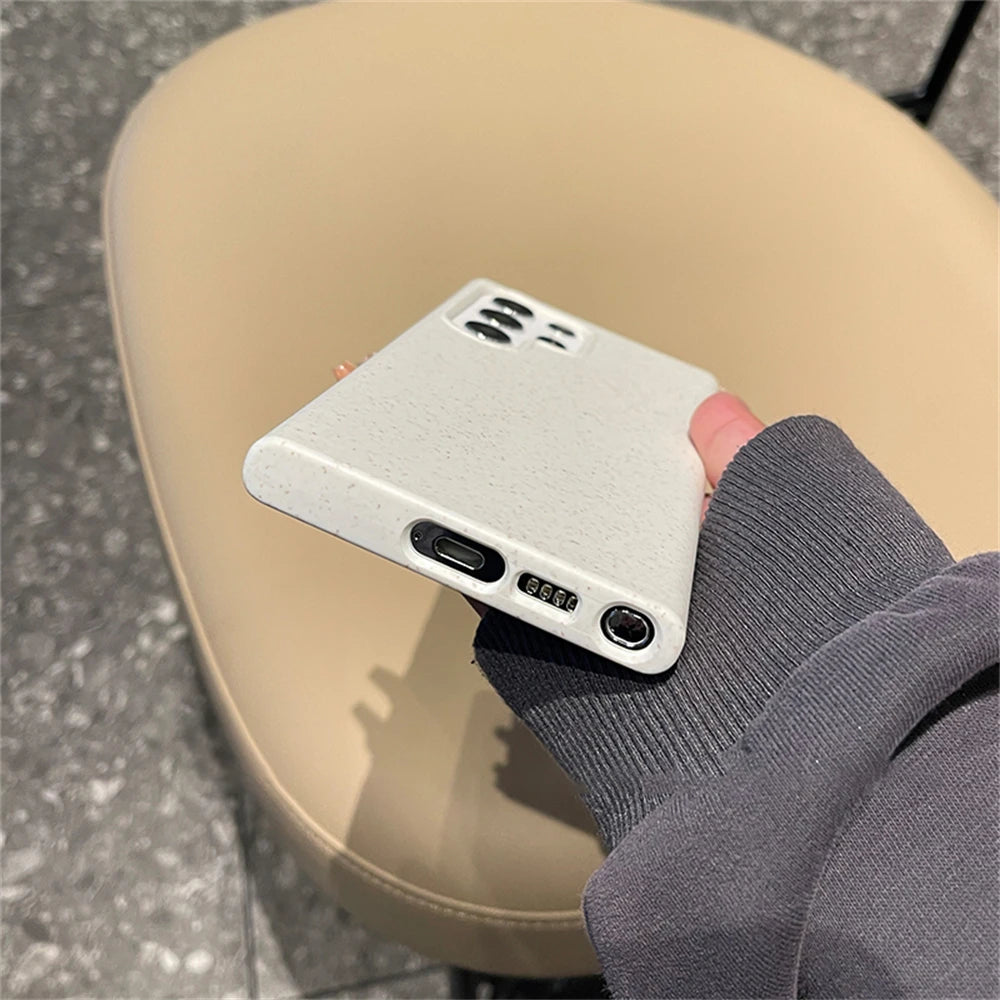 Person holding a white phone case with a textured finish on a beige stool.