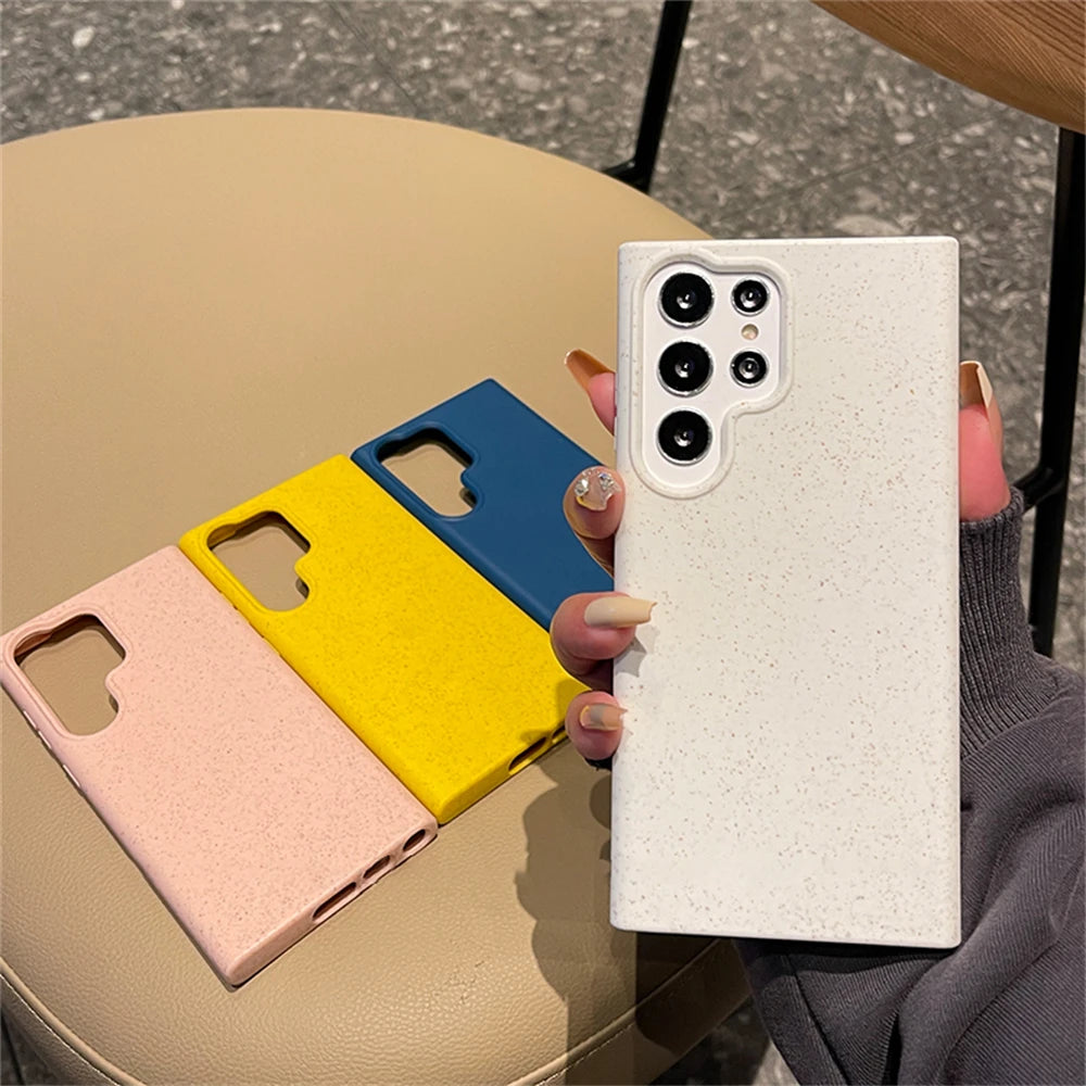Three colorful phone cases on a table with a hand holding a white textured case.