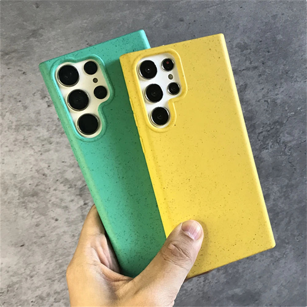 Two phone cases, one green and one yellow, held against a gray background.