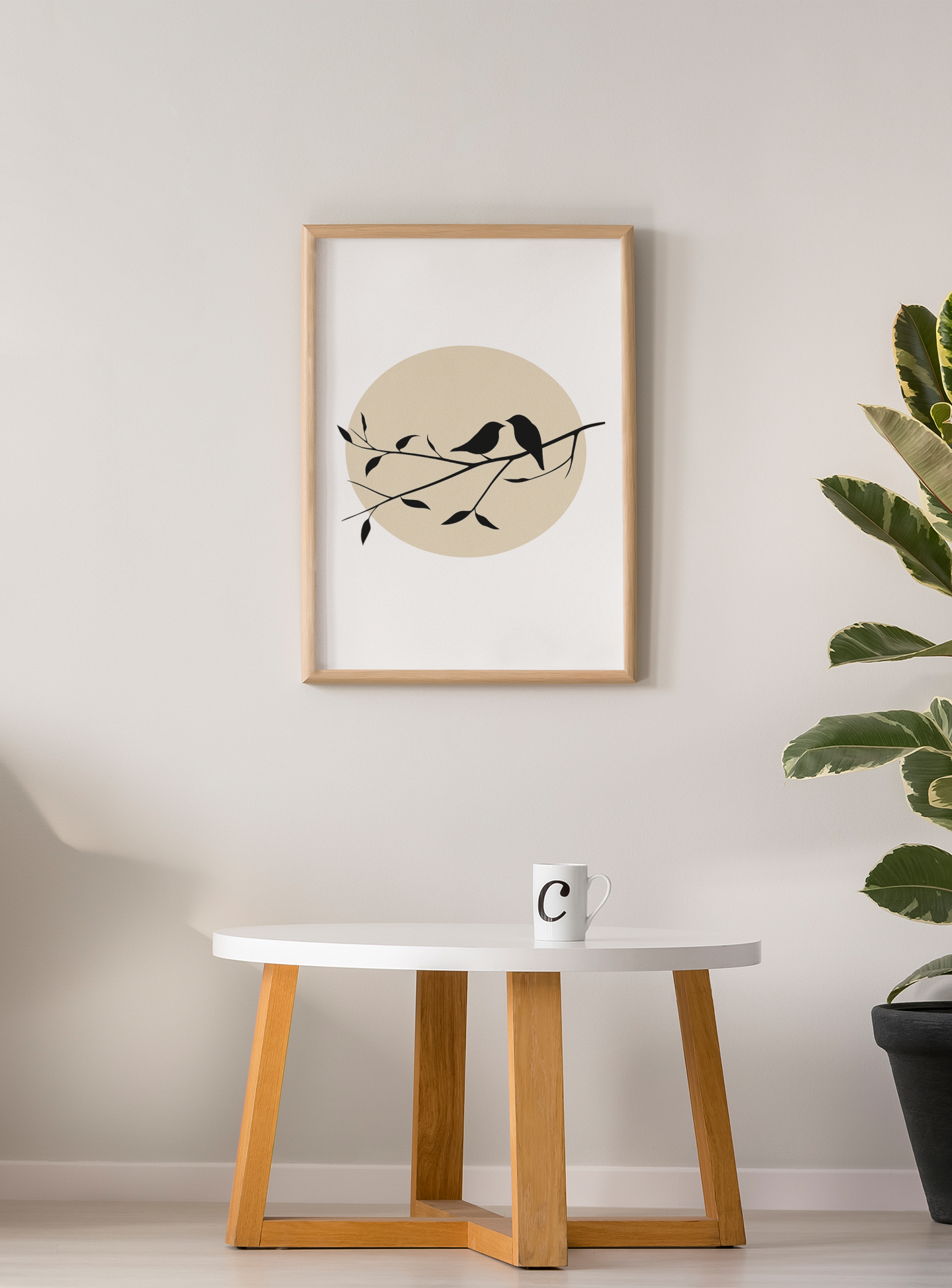 Framed bird silhouette poster with beige sun above a white coffee table and mug, styled in a modern room with light walls and a leafy green plant.