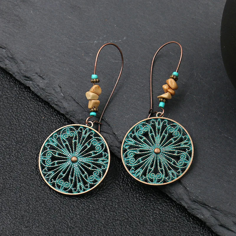 Pair of earrings with intricate design on a dark surface