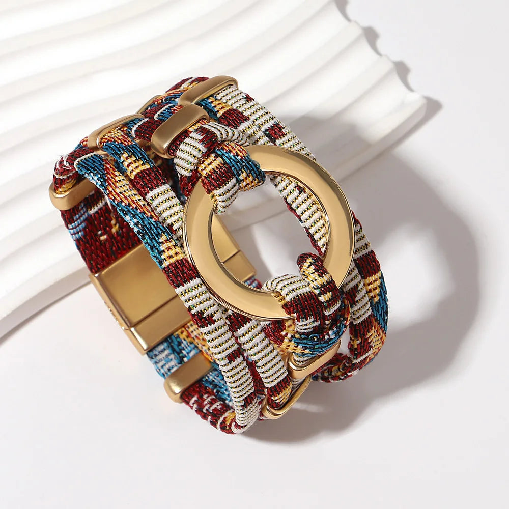 Multicolored braided bracelet with gold clasp on a white background