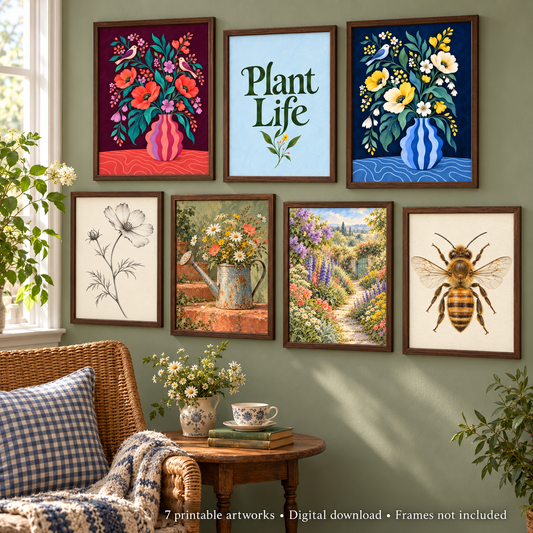A styled interior scene showing seven framed botanical and floral art prints mounted on a sage green wall above a wicker chair and small table. The prints include colorful flowers, a blue vase, a bee illustration, a black-and-white flower sketch, and a garden landscape with the words 'Plant Life.