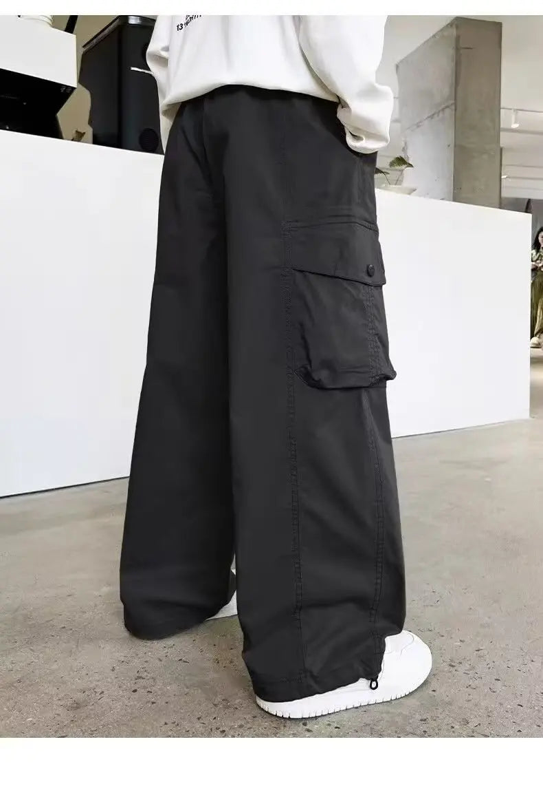 Person wearing black cargo pants with a white shirt in an urban setting