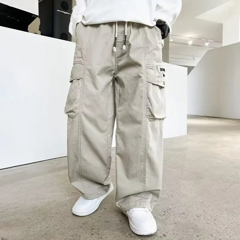 Person wearing grey cargo pants and white sneakers in a minimalistic indoor setting