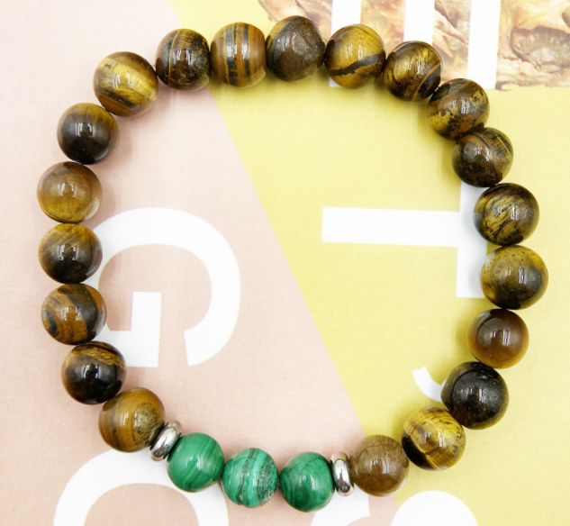 Bracelet with tiger eye and green beads on a neutral background