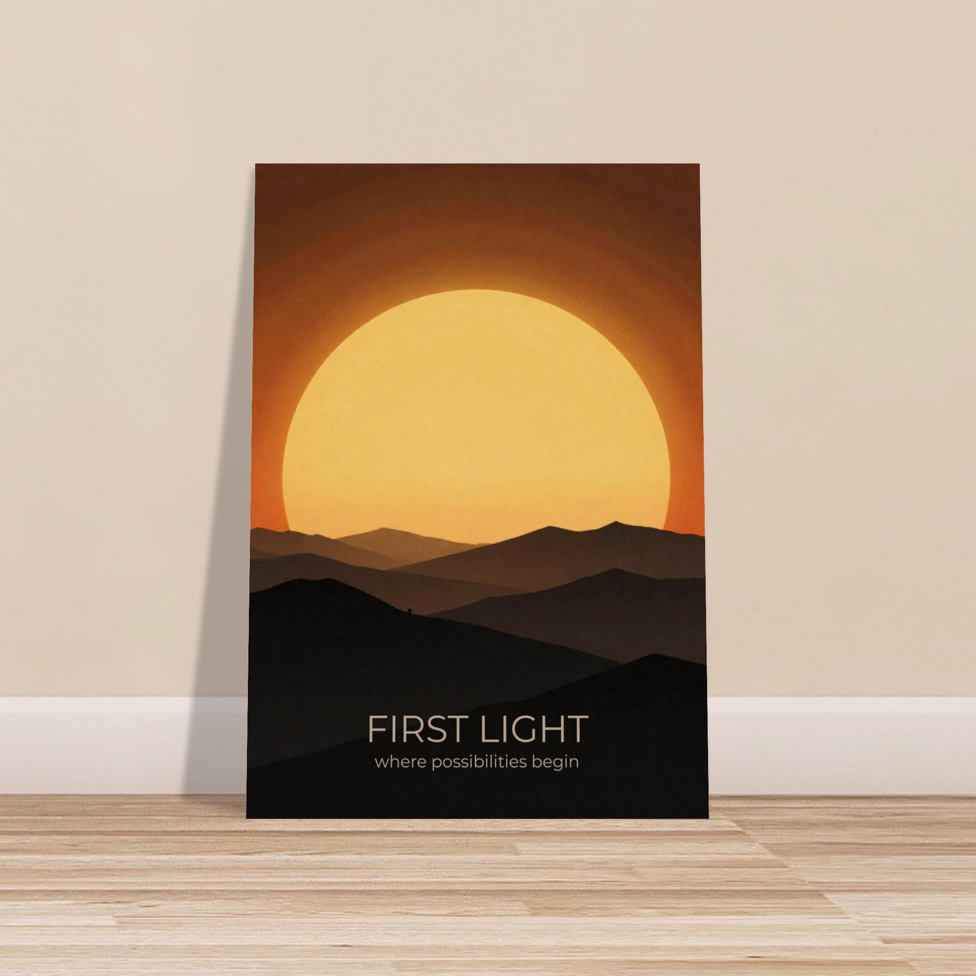 First Light poster displayed on a wooden floor, highlighting a dramatic sunrise and layered mountain silhouettes in a minimalist design.