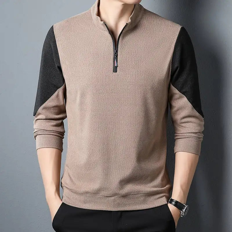Beige and black long-sleeve shirt with a zipper on a gray background