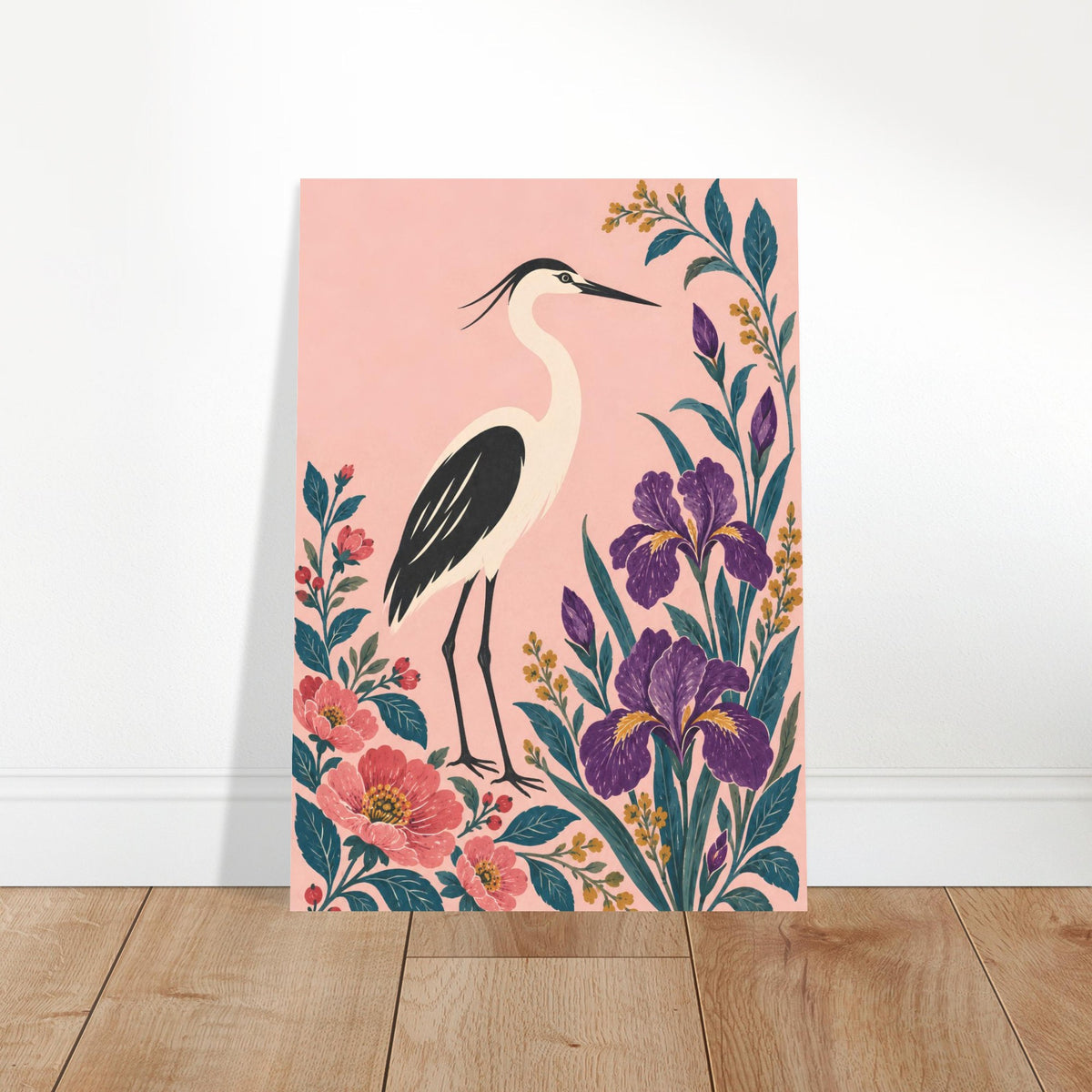 A vertical art print featuring a heron bird and purple irises on a pink background, leaning against a white wall on a light wood floor.