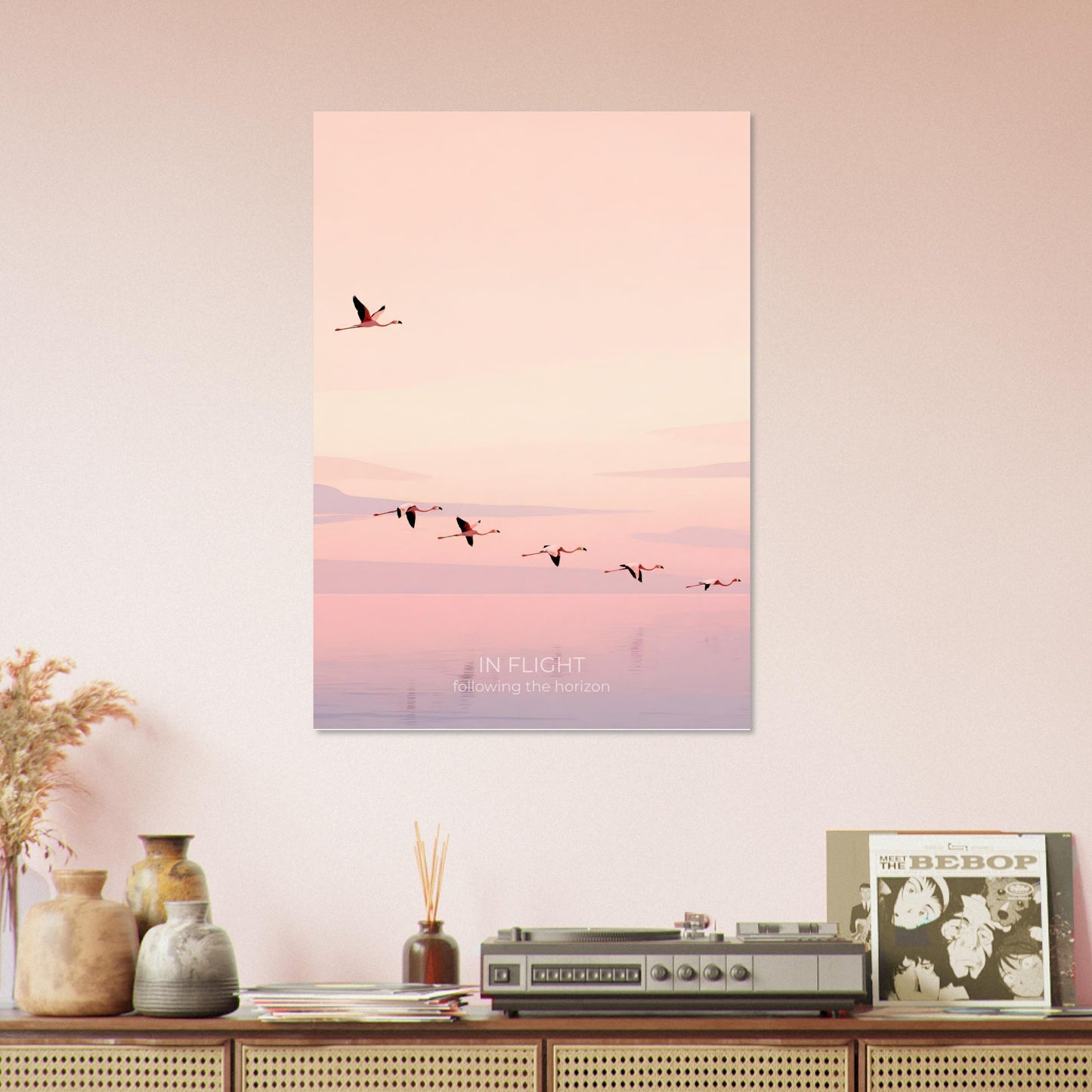 In Flight flamingo poster displayed on a shelf arrangement, featuring minimalist birds soaring above calm pastel waters.