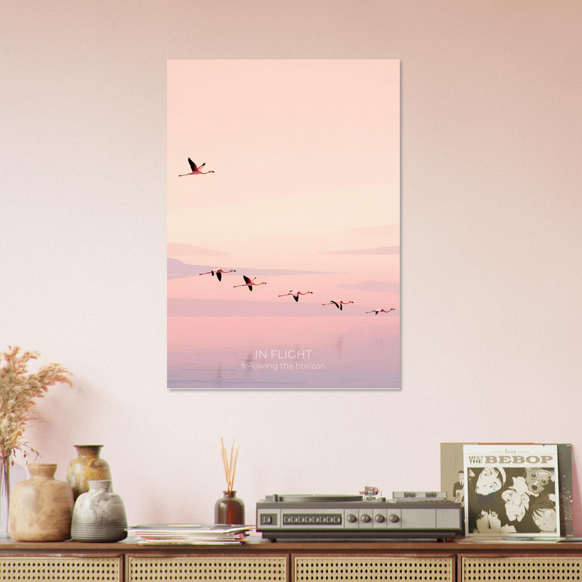 In Flight flamingo poster displayed on a shelf arrangement, featuring minimalist birds soaring above calm pastel waters.