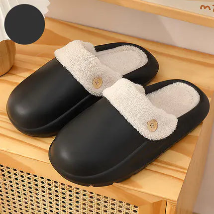 Black slippers with white fur lining on a wooden surface