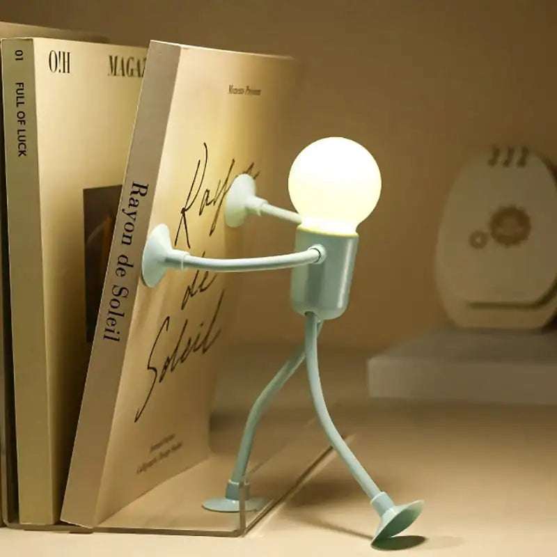 Novelty lamp shaped like a person with a light bulb for a head, placed on books.
