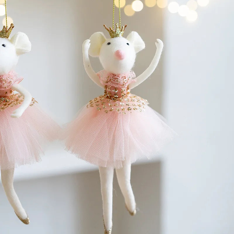 Two decorative mouse figurines in ballerina costumes with pink tutus and gold crowns on a light background.