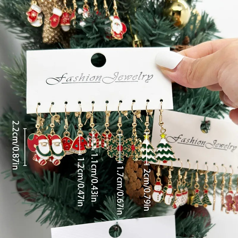 Hand holding a card with Christmas-themed earrings on a tree background