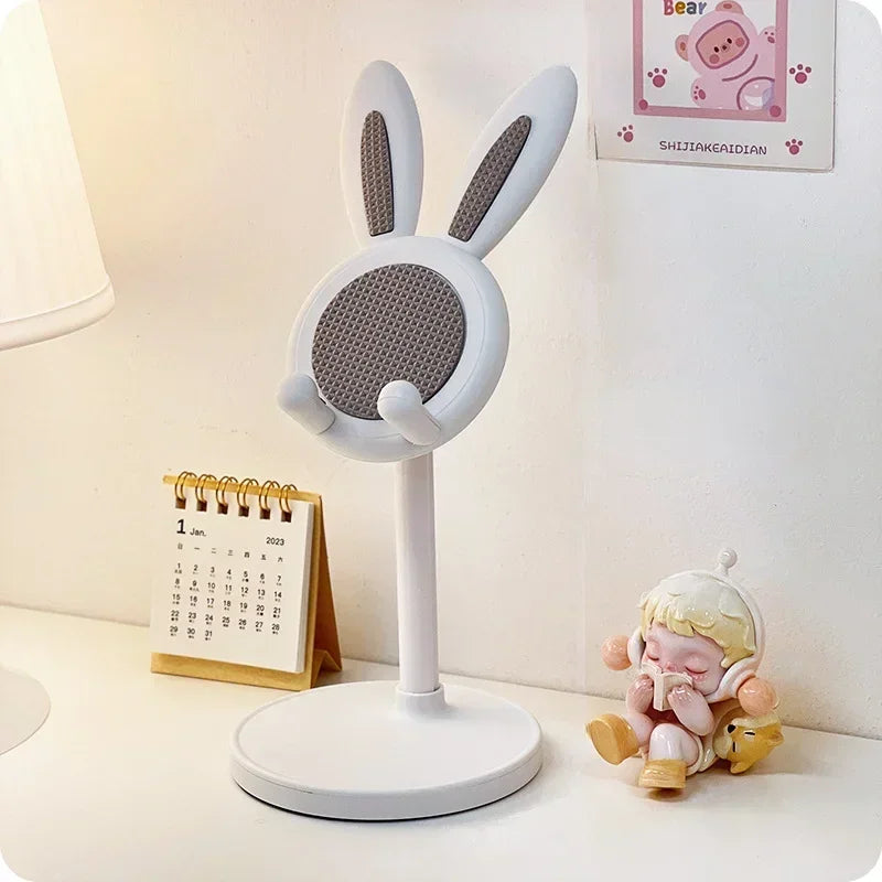 Desk lamp with bunny ears on a desk next to a calendar and small figurine
