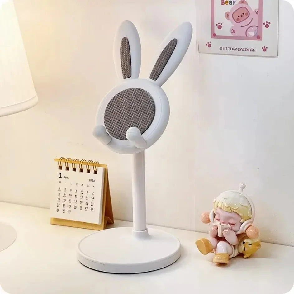White rabbit-shaped microphone on a stand with a small calendar and figurine in the background.