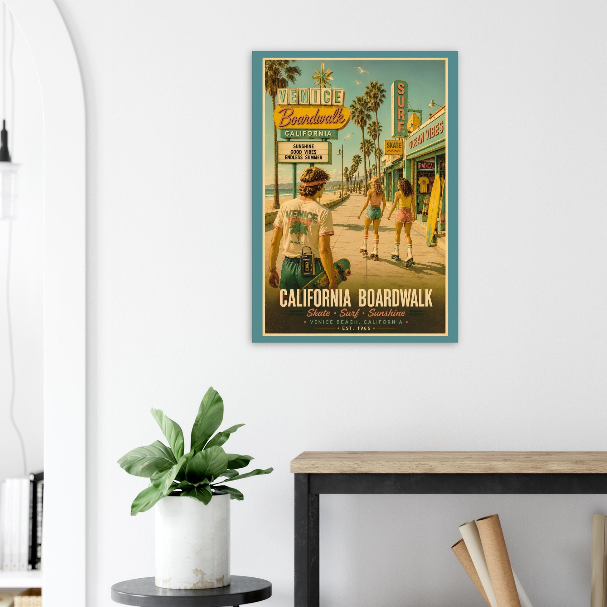 Vintage-style poster of a beach scene with people on a California Boardwalk, framed on a wall above a desk.