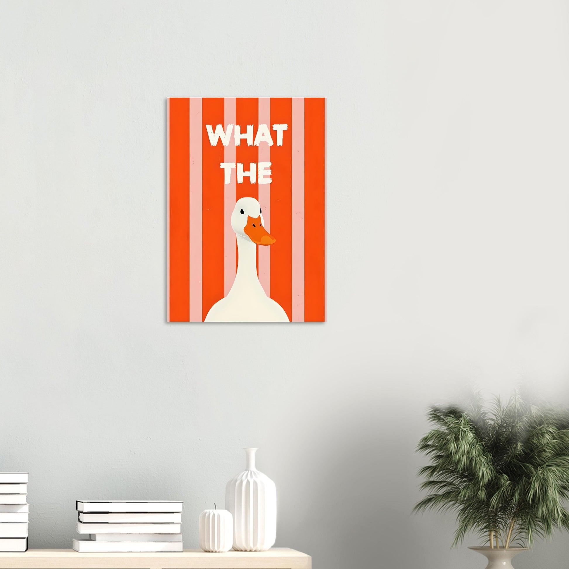 Canvas print with a duck illustration and 'WHAT THE' text on a red striped background, displayed on a wall.