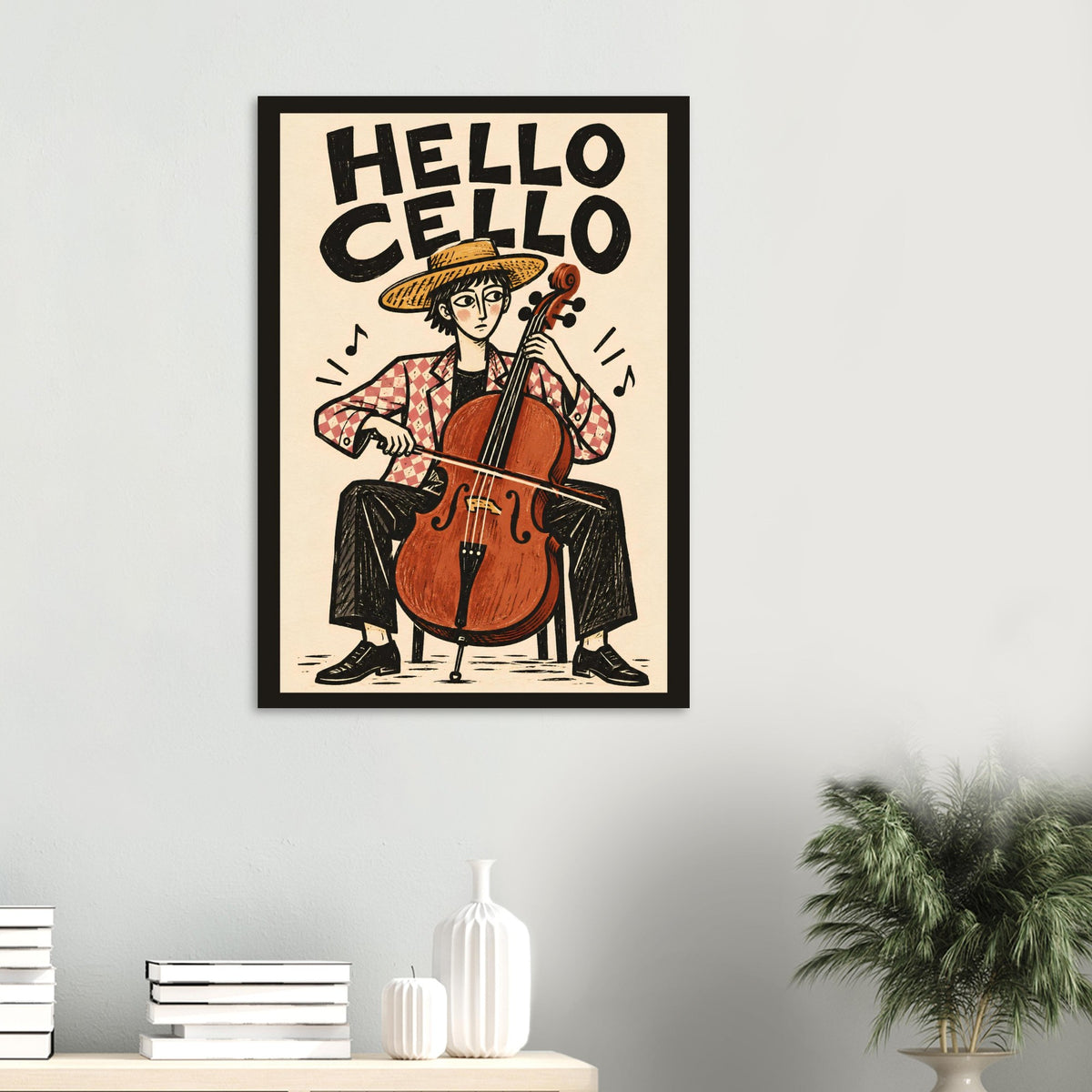 A framed art print featuring a retro-style illustration of a person playing a cello with the text 'HELLO CELLO' at the top, displayed on a light gray wall above a shelf with books and decorative vases, with a potted plant on the right.
