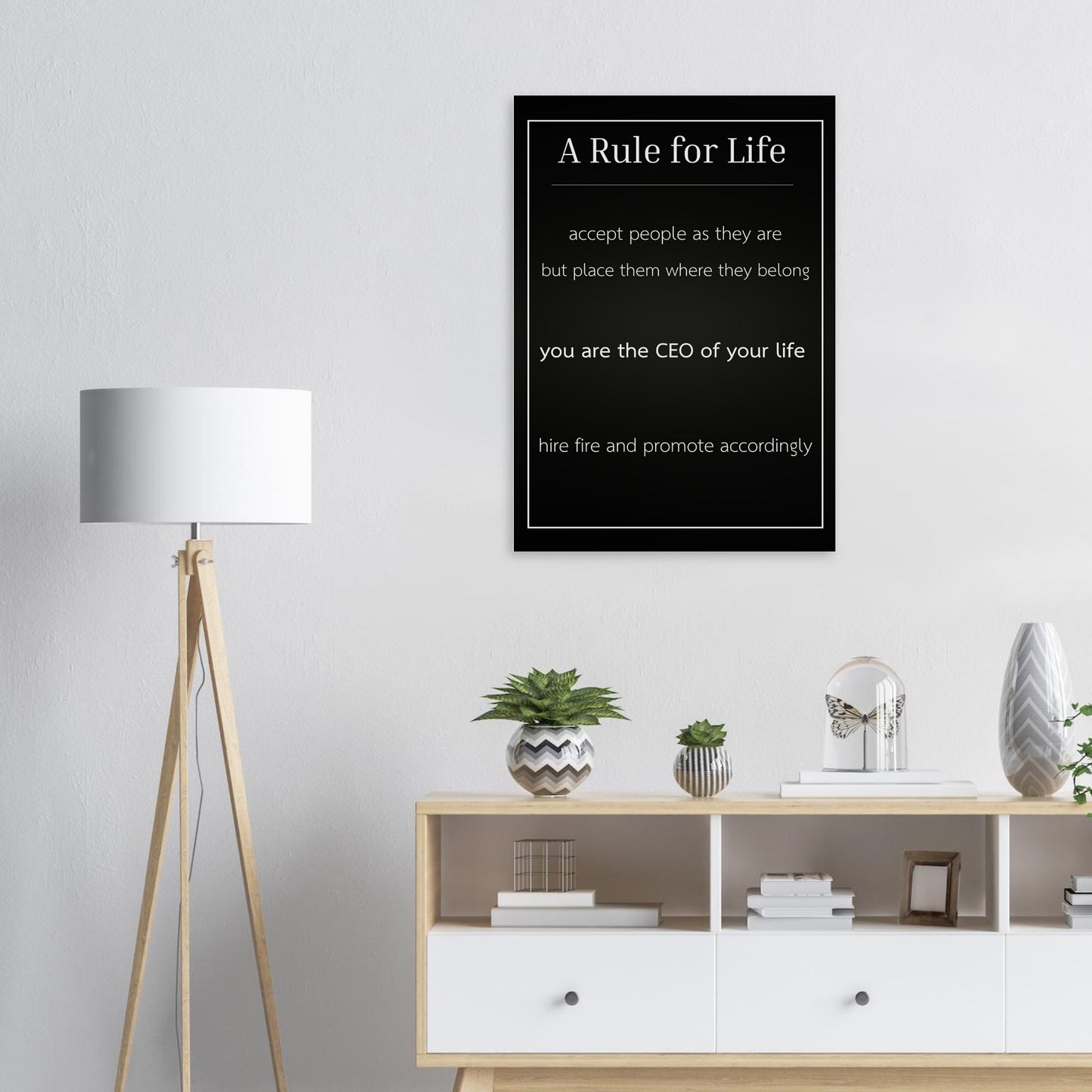 Framed poster with 'A Rule for Life' quote on a wall above a shelf with decor items.
