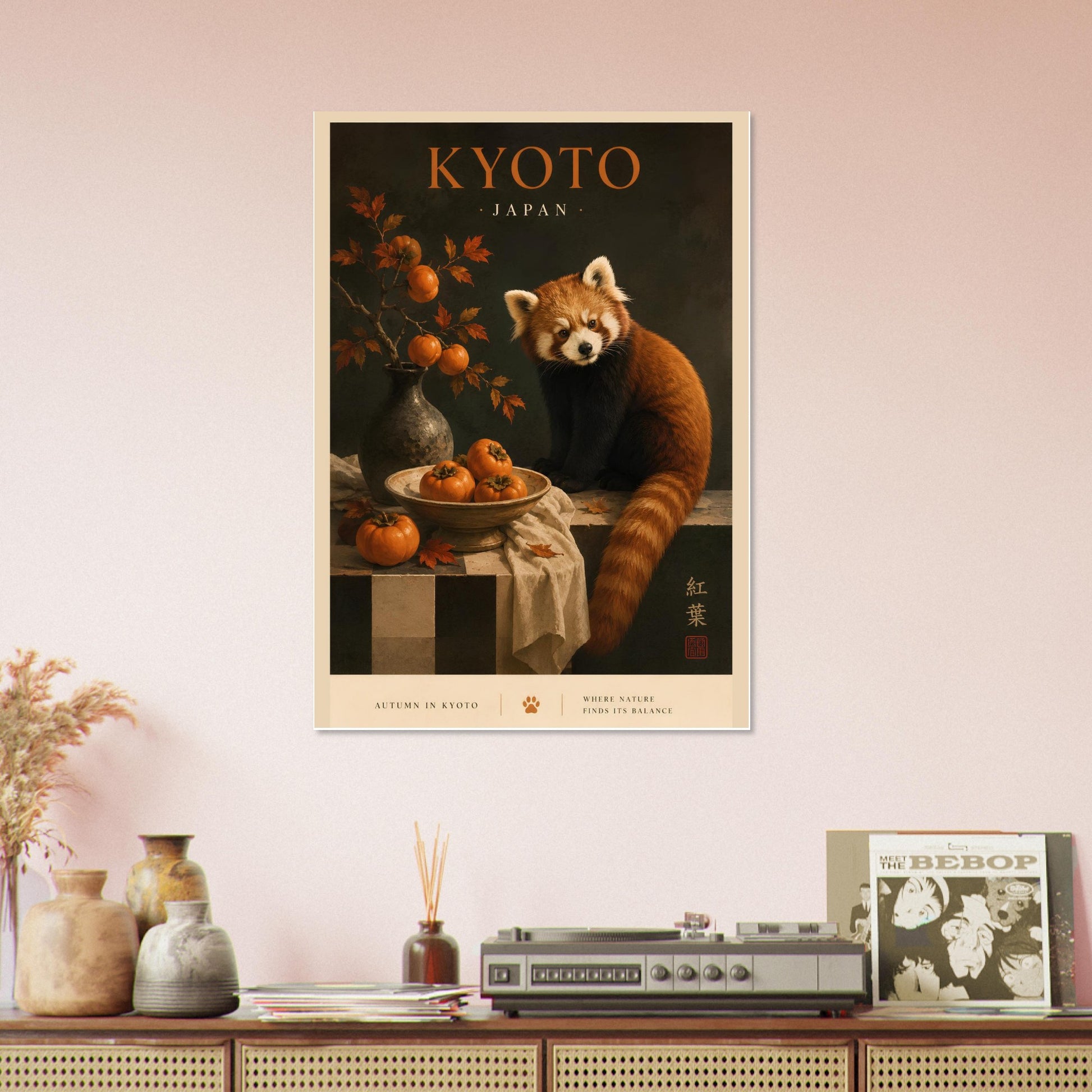 Framed poster of a red panda in Kyoto, Japan, on a wall above a wooden cabinet with decorative items.