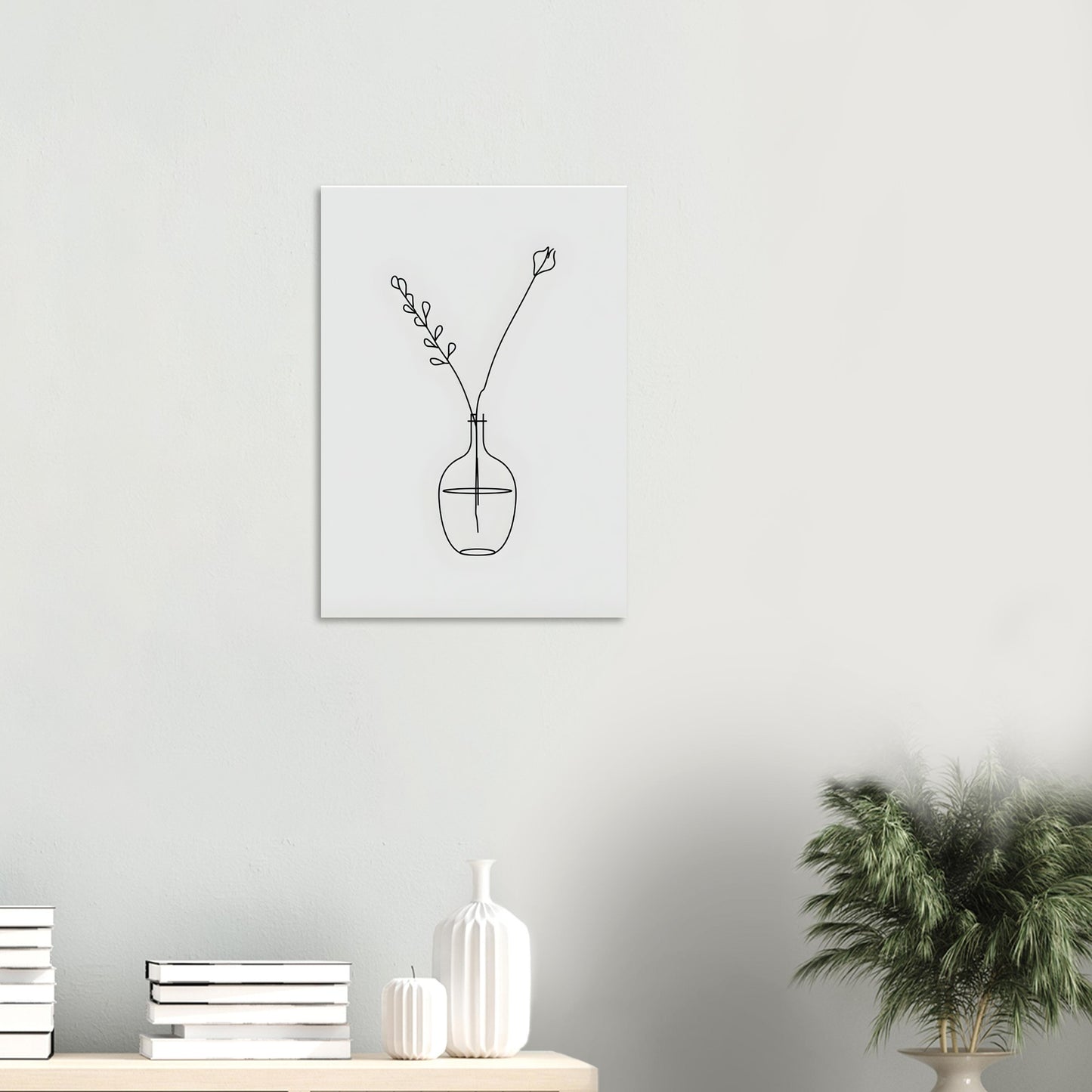 Minimalist line art of a vase with branches on a white wall above a shelf with decorative items.