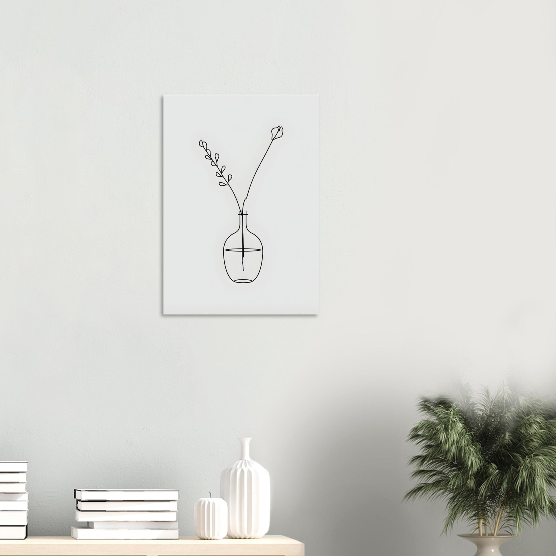 Minimalist line art of a vase with branches on a white wall above a shelf with decorative items.