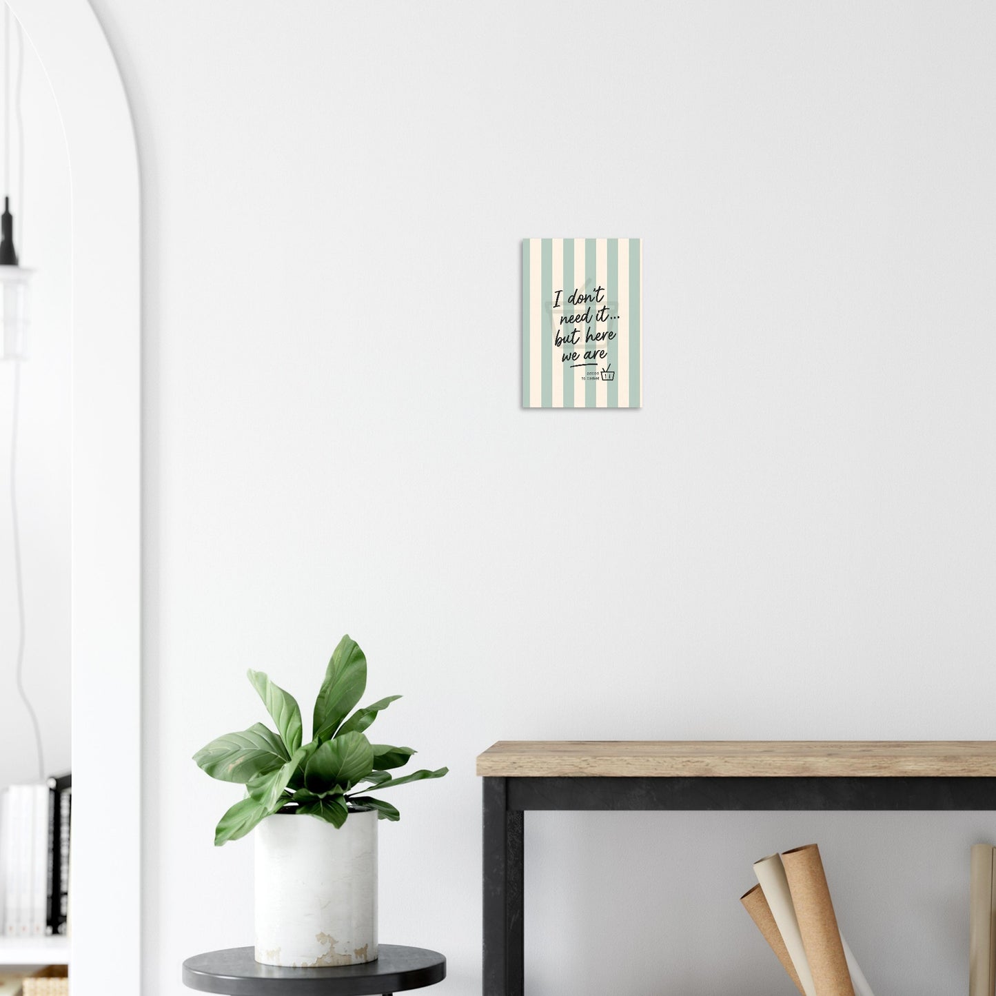 Decorative book with a striped cover on a white wall next to a plant and desk.