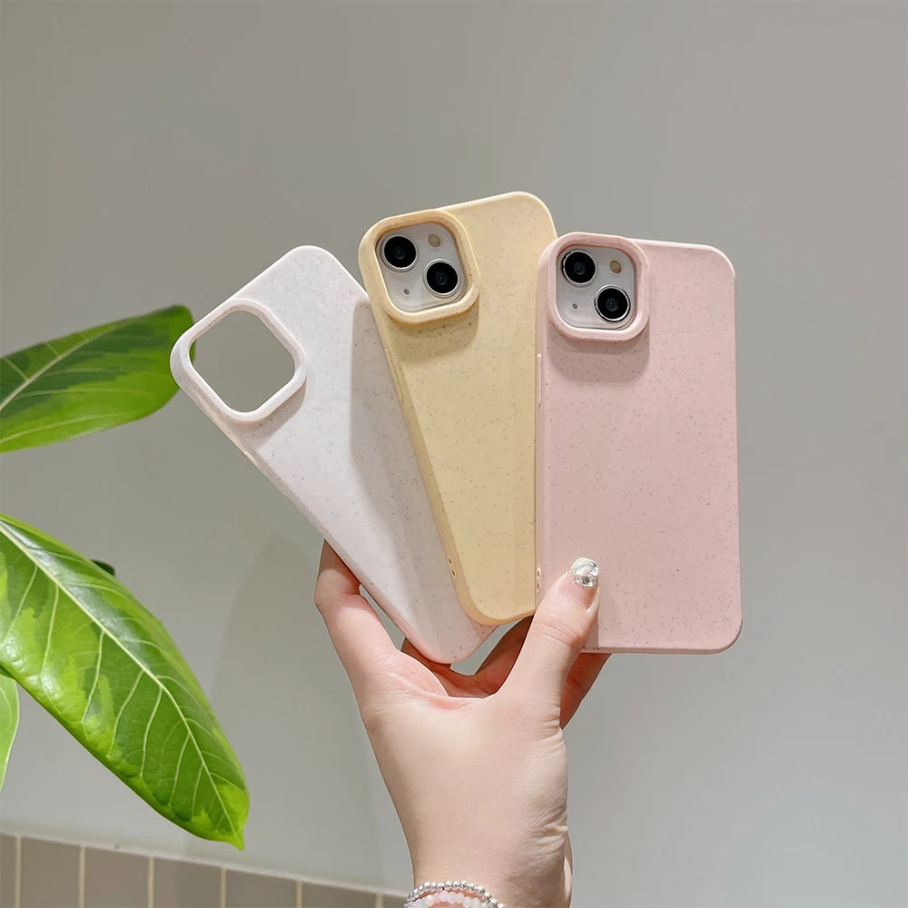 Three phone cases in white, beige, and pink held by a hand with a plant in the background.