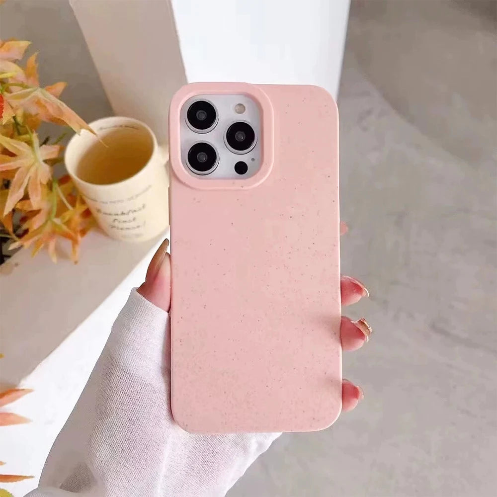 Pink phone case held by a hand with a blurred background