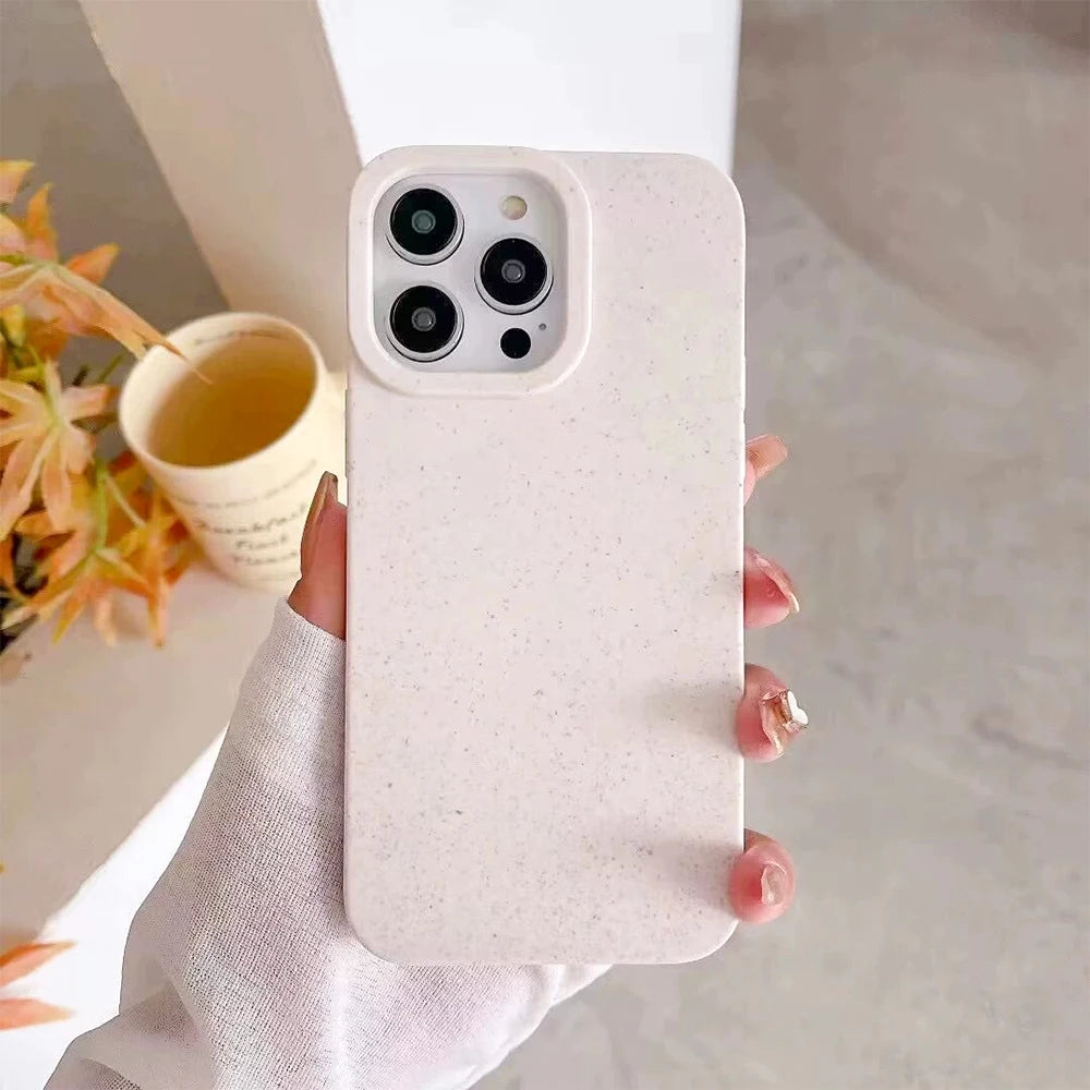 Phone case held by a hand with a blurred background of a cup and flowers