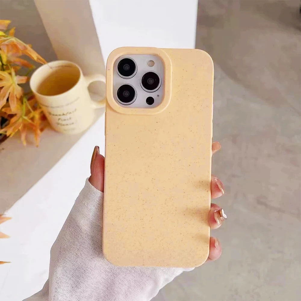 Hand holding a yellow phone case with a blurred background of a cup and flowers.
