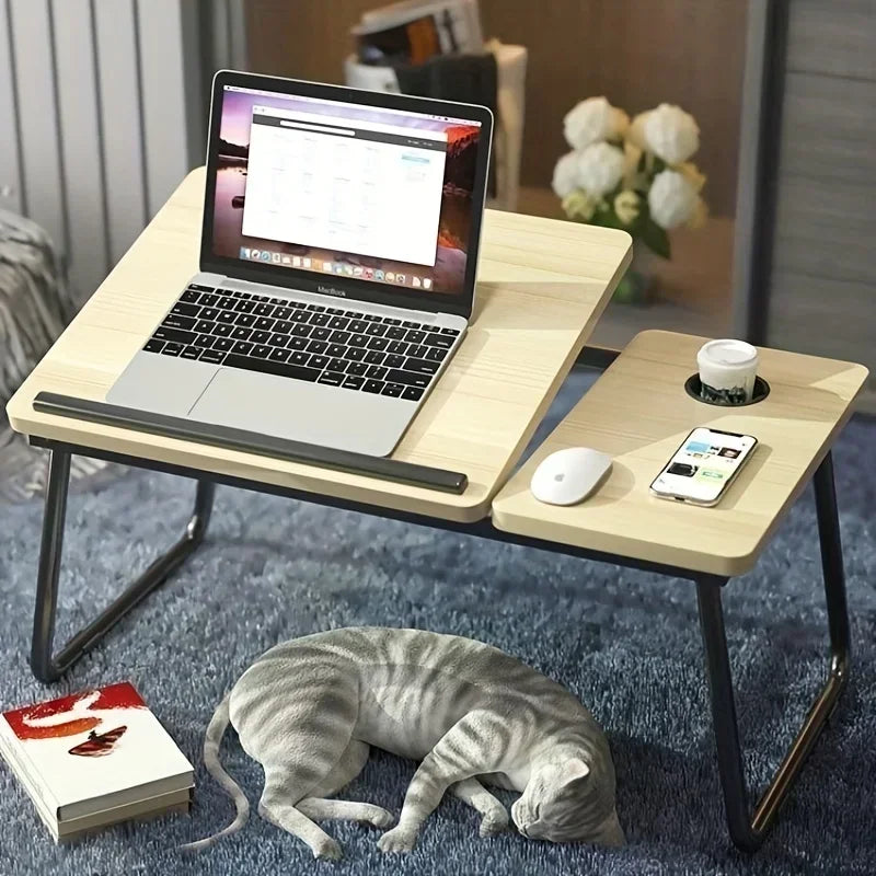 Portable laptop desk with a cat lying on the floor in a home setting