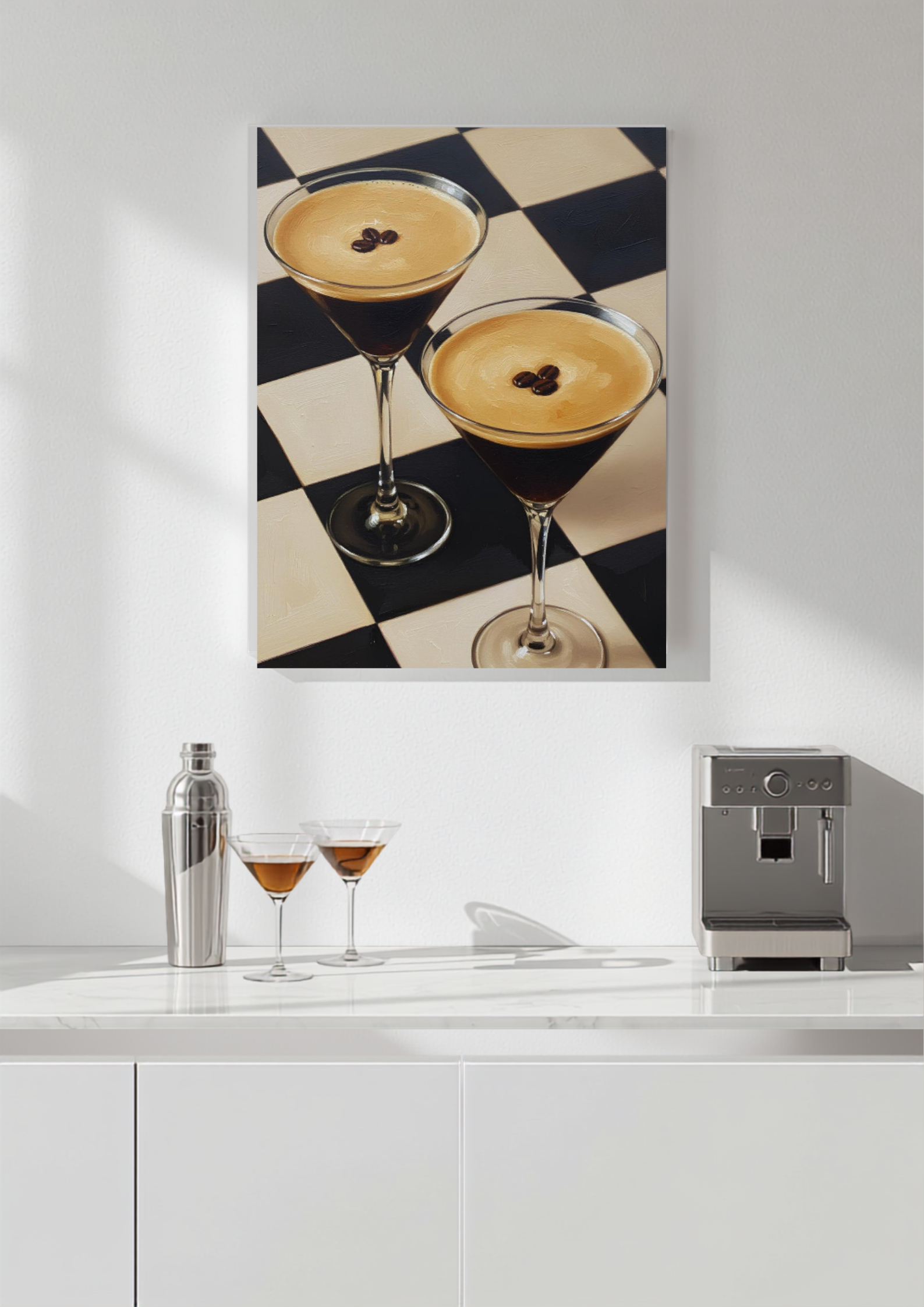 A vertical canvas wall art print depicting two martini cocktails on a black and cream checkered floor, displayed on a white wall above a kitchen counter with a shaker, two glasses, and an espresso machine.