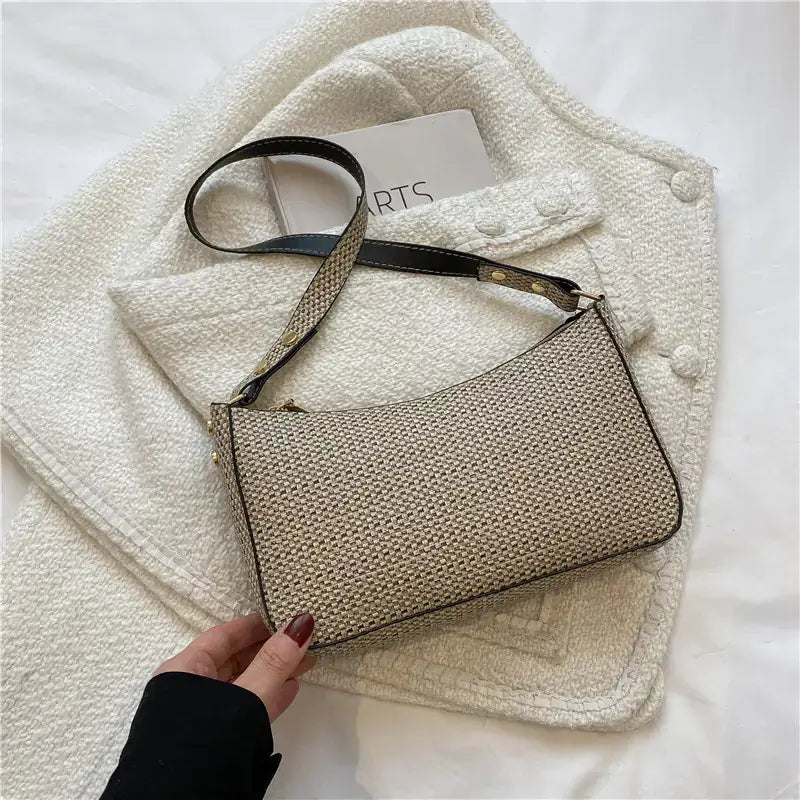 Cream PU leather underarm bag with curved edges and a minimal zip design, photographed against a neutral background on a white small jacket
