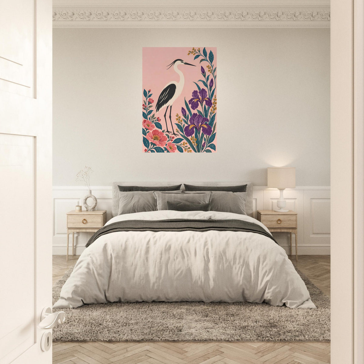 A framed wall art print featuring a pink heron with colorful floral elements, displayed above a neatly made bed in a bright, modern bedroom.